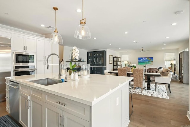 939 Moonstone Ct, Encinitas, CA 92024 - kitchen featuring a sink, built in appliances, an island with sink, white cabinets, and open floor plan