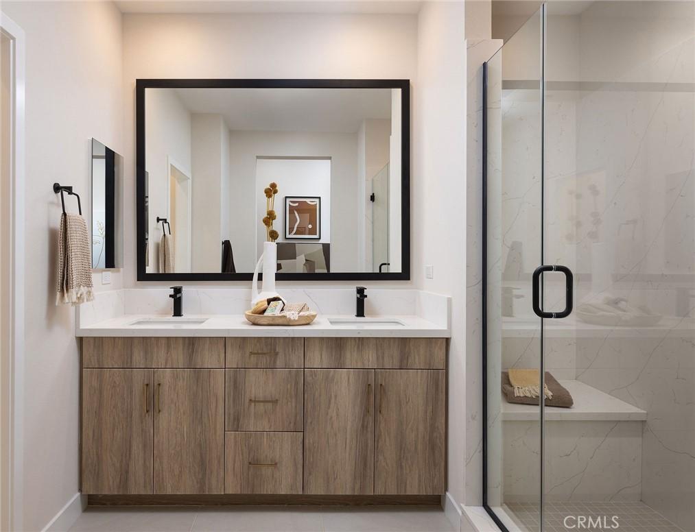 119 N First Ave, Upland, CA 91786 - bathroom featuring double vanity, a marble finish shower, and baseboards