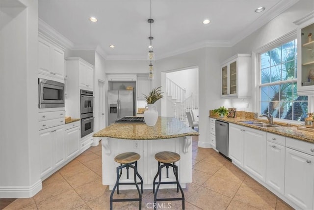 10 Edendale St, Ladera Ranch, CA 92694 - kitchen with stainless steel appliances, a sink, a center island, white cabinets, and light stone counters