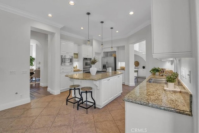 10 Edendale St, Ladera Ranch, CA 92694 - kitchen with arched walkways, stainless steel appliances, a sink, a kitchen island, and recessed lighting
