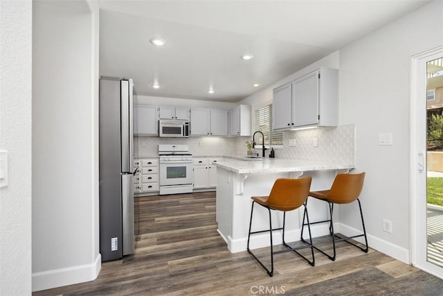 42192 Delmonte St, Temecula, CA 92591 - kitchen with appliances with stainless steel finishes, a peninsula, tasteful backsplash, baseboards, and a kitchen breakfast bar