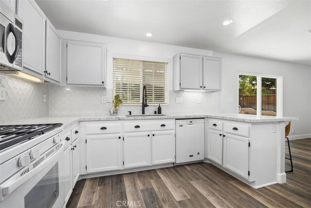42192 Delmonte St, Temecula, CA 92591 - kitchen with white appliances, a sink, a peninsula, dark wood-style floors, and white cabinetry