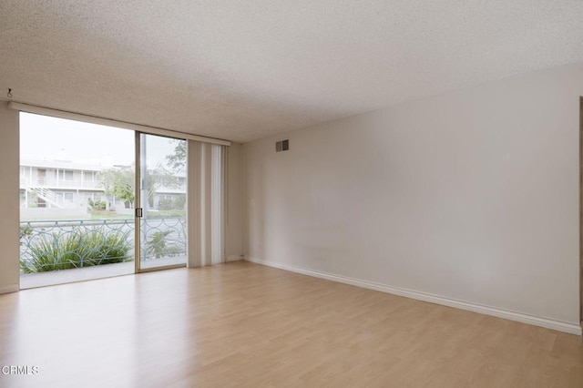 1000 Cordova St Unit 103, Pasadena, CA 91106 - spare room with light wood-type flooring, expansive windows, a textured ceiling, and baseboards