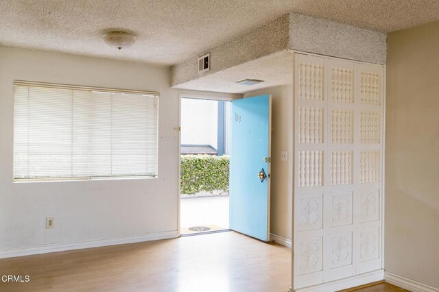 1000 Cordova St Unit 103, Pasadena, CA 91106 - entryway featuring wood finished floors, a textured ceiling, and baseboards