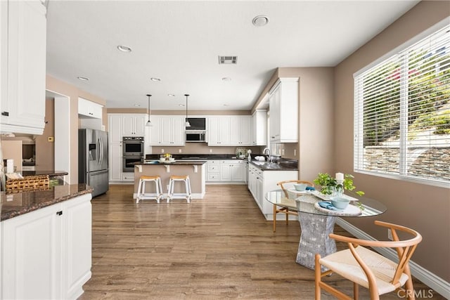 2437 N Eaton Ct, Orange, CA 92867 - kitchen featuring stainless steel appliances, light wood-style floors, white cabinets, a kitchen island, and recessed lighting