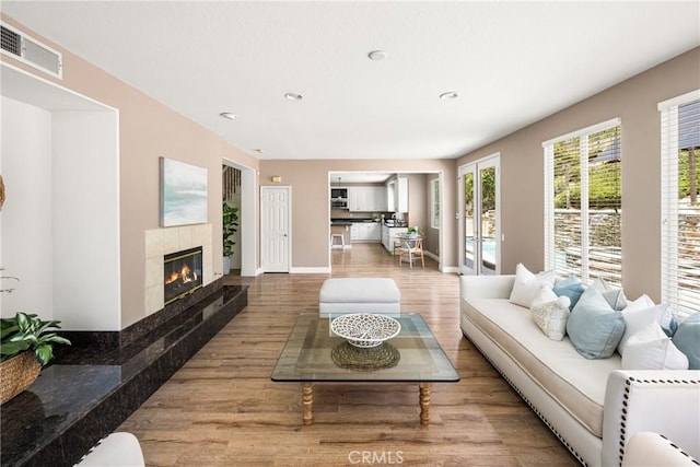 2437 N Eaton Ct, Orange, CA 92867 - living room with wood finished floors, a tiled fireplace, and recessed lighting