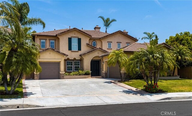 2437 N Eaton Ct, Orange, CA 92867 - mediterranean / spanish home with stucco siding, driveway, a chimney, and a tile roof