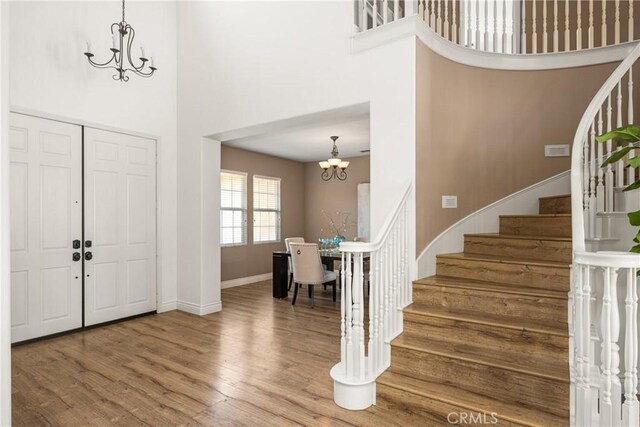 2437 N Eaton Ct, Orange, CA 92867 - foyer entrance with a chandelier, a high ceiling, stairs, and wood finished floors