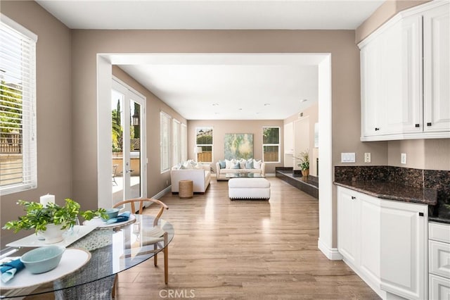 2437 N Eaton Ct, Orange, CA 92867 - kitchen with light wood-style floors, white cabinets, open floor plan, and dark stone countertops