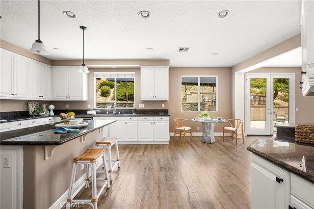 2437 N Eaton Ct, Orange, CA 92867 - kitchen featuring plenty of natural light, a kitchen breakfast bar, white cabinets, light wood-type flooring, and recessed lighting