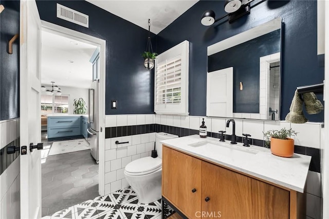 17949 Archwood St, Reseda, CA 91335 - bathroom with vanity, tile patterned floors, a wainscoted wall, and tile walls