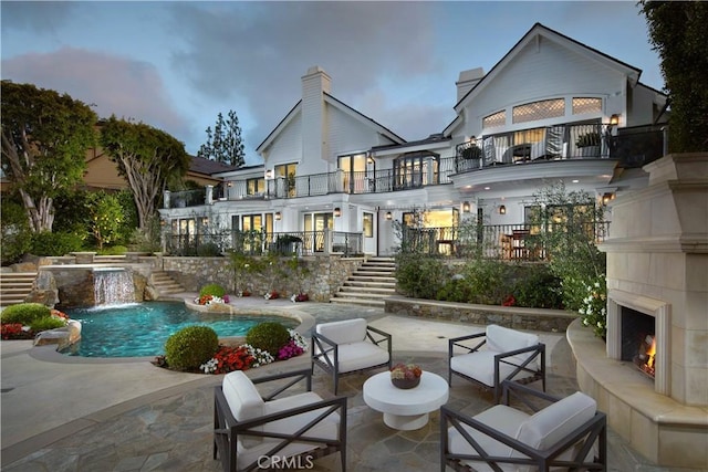 2 Royal Saint George Rd, Newport Beach, CA 92660 - back of house featuring stairs, a tile fireplace, a balcony, a patio, and an outdoor pool