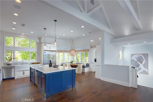 2 Royal Saint George Rd, Newport Beach, CA 92660 - kitchen with stainless steel appliances, a large island with sink, light countertops, beamed ceiling, and healthy amount of natural light