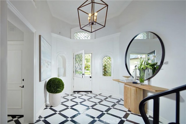 2 Royal Saint George Rd, Newport Beach, CA 92660 - entrance foyer with a decorative wall, a chandelier, a high ceiling, and ornamental molding