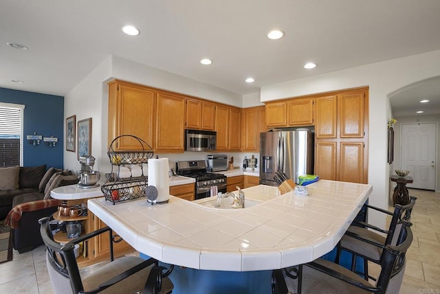 320 Corte Castillo, Chula Vista, CA 91914 - kitchen featuring stainless steel appliances, arched walkways, tile counters, a breakfast bar, and recessed lighting