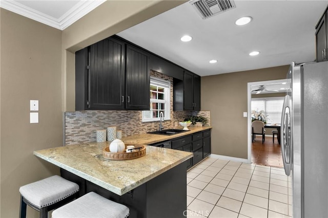 825 E Palm Ave, Monrovia, CA 91016 - kitchen with freestanding refrigerator, a sink, dark cabinets, tasteful backsplash, and light tile patterned floors