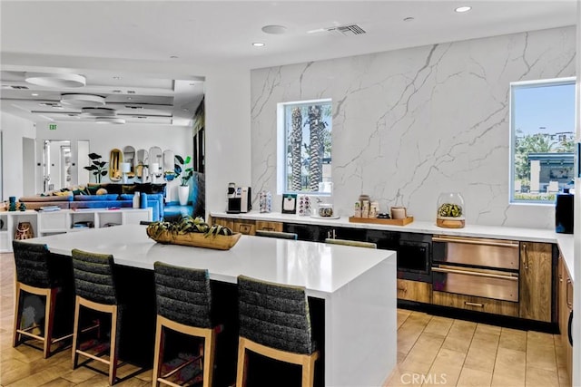 11047 Wander Dr, Rancho Cucamonga, CA 91730 - kitchen featuring light countertops, a warming drawer, recessed lighting, a center island, and a breakfast bar area