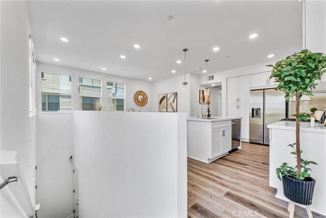 11047 Wander Dr, Rancho Cucamonga, CA 91730 - kitchen with appliances with stainless steel finishes, a sink, recessed lighting, white cabinets, and light wood-style floors