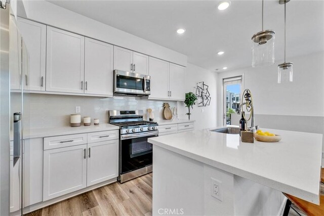 11047 Wander Dr, Rancho Cucamonga, CA 91730 - kitchen with appliances with stainless steel finishes, recessed lighting, white cabinetry, light wood-type flooring, and light countertops