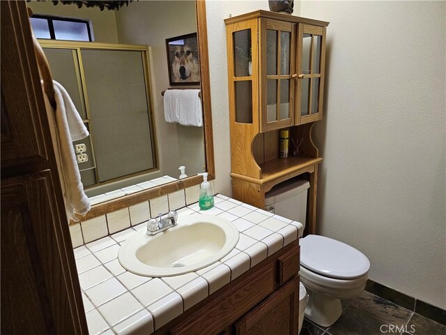 43133 Moonridge Rd, Big Bear, CA 92315 - bathroom featuring toilet, vanity, a shower with shower door, a textured wall, and baseboards