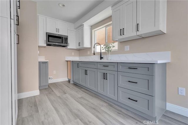 22022 Pioneer Blvd Unit A & B, Hawaiian Gardens, CA 90716 - kitchen featuring stainless steel microwave, gray cabinetry, light wood-type flooring, light stone counters, and recessed lighting