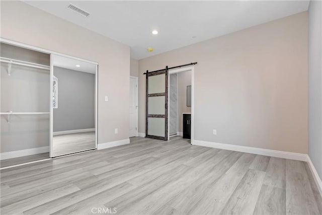 22022 Pioneer Blvd Unit A & B, Hawaiian Gardens, CA 90716 - unfurnished bedroom featuring a barn door, light wood-type flooring, recessed lighting, and a closet