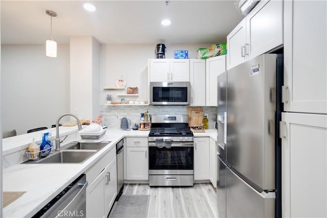 12668 Chapman Ave Unit 2108, Garden Grove, CA 92840 - kitchen with stainless steel appliances, light wood-type flooring, a sink, white cabinets, and recessed lighting