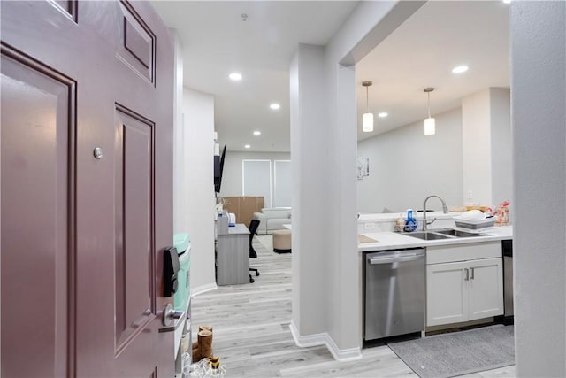 12668 Chapman Ave Unit 2108, Garden Grove, CA 92840 - kitchen with dishwasher, light wood-style floors, a sink, light countertops, and white cabinets