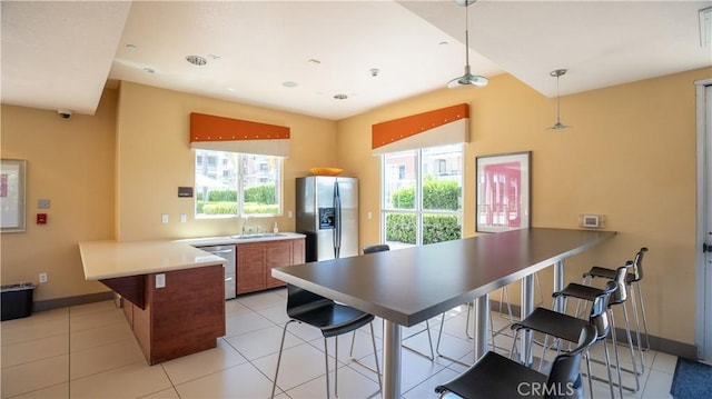 12668 Chapman Ave Unit 2108, Garden Grove, CA 92840 - kitchen with stainless steel appliances, a peninsula, a sink, brown cabinetry, and a kitchen breakfast bar