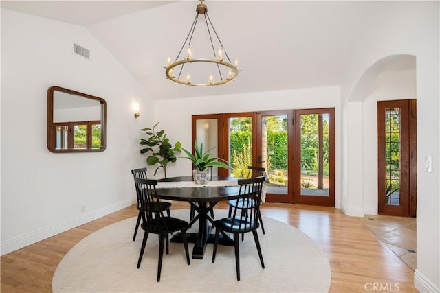 1247 Journeys End Dr, La Canada Flintridge, CA 91011 - dining space with a chandelier, lofted ceiling, arched walkways, light wood finished floors, and french doors