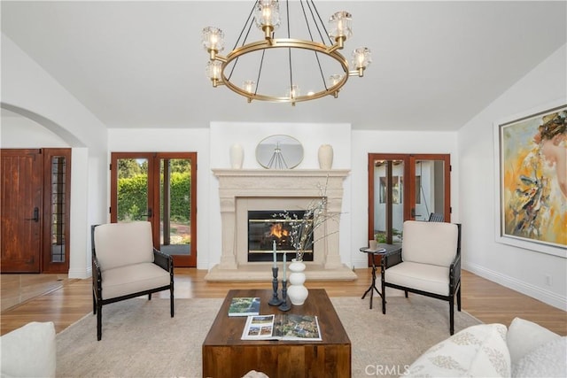1247 Journeys End Dr, La Canada Flintridge, CA 91011 - living area featuring a chandelier, lofted ceiling, french doors, wood finished floors, and a high end fireplace