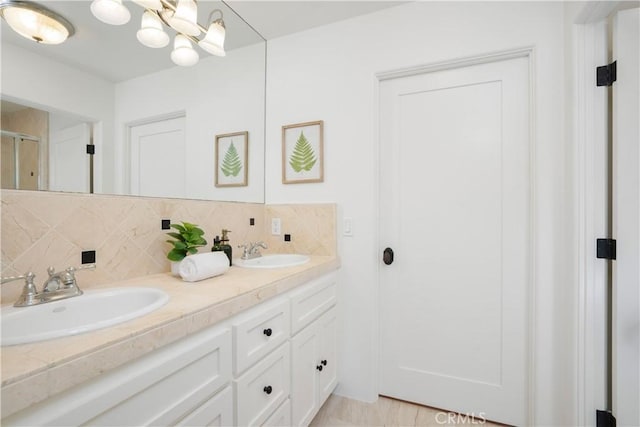 1247 Journeys End Dr, La Canada Flintridge, CA 91011 - full bathroom with double vanity, decorative backsplash, a shower with door, and a chandelier
