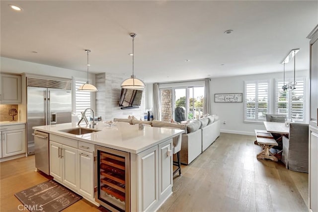 2393 Ocean St, Carlsbad, CA 92008 - kitchen featuring beverage cooler, stainless steel appliances, light countertops, light wood finished floors, and open floor plan