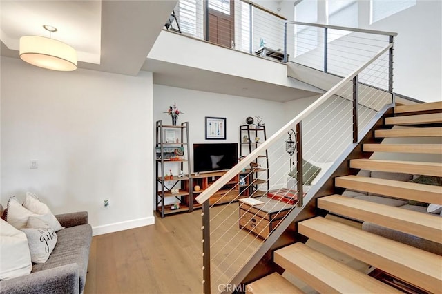 2393 Ocean St, Carlsbad, CA 92008 - staircase featuring baseboards, wood finished floors, and a towering ceiling
