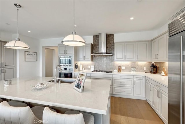 2393 Ocean St, Carlsbad, CA 92008 - kitchen featuring wall chimney range hood, stainless steel appliances, a sink, tasteful backsplash, and light wood-style flooring