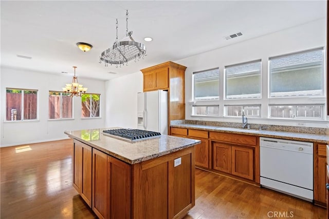 1550 Strawberry Ave, Arroyo Grande, CA 93420 - kitchen featuring white appliances, a sink, brown cabinetry, dark wood-style flooring, and decorative light fixtures
