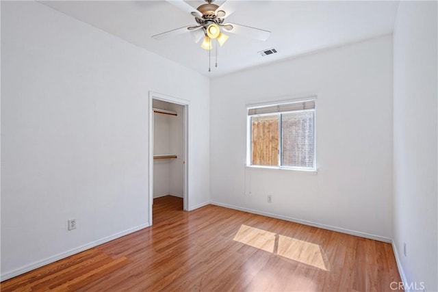 1550 Strawberry Ave, Arroyo Grande, CA 93420 - unfurnished bedroom featuring wood finished floors, baseboards, a walk in closet, a closet, and ceiling fan