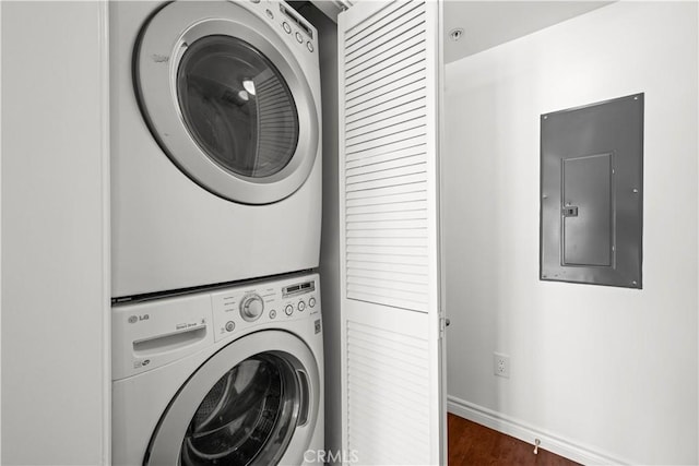 5633 Carlton Way Unit 503, Hollywood, CA 90028 - laundry area with stacked washer / dryer, electric panel, baseboards, and dark wood-type flooring