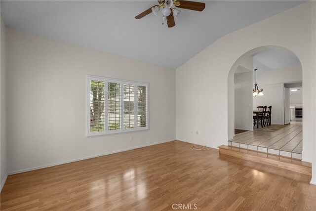 26320 Ivrea Pl, Valencia, CA 91355 - empty room with arched walkways, lofted ceiling, a ceiling fan, wood finished floors, and baseboards