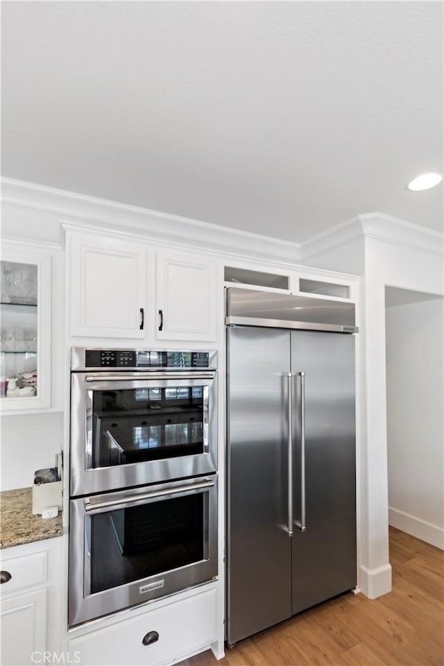 23556 Kathryn St, Murrieta, CA 92562 - kitchen featuring appliances with stainless steel finishes, crown molding, white cabinets, light wood-type flooring, and light stone counters