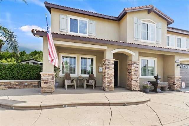 14160 Vai Brothers Dr, Rancho Cucamonga, CA 91739 - back of property featuring stucco siding, a porch, stone siding, and a tile roof