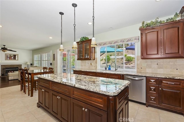 14160 Vai Brothers Dr, Rancho Cucamonga, CA 91739 - kitchen featuring a sink, stainless steel dishwasher, a lit fireplace, light tile patterned flooring, and a ceiling fan