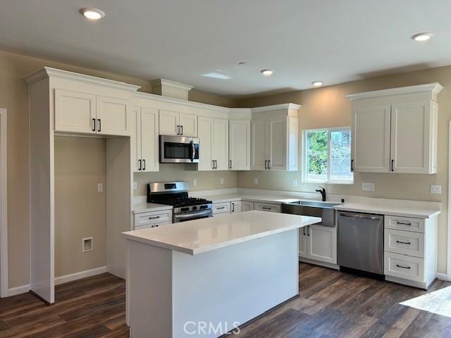 1488 Bille Rd, Paradise, CA 95969 - kitchen with stainless steel appliances, dark wood-style flooring, a kitchen island, white cabinets, and light countertops