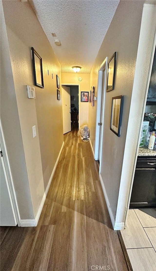 7534 Layton St, Rancho Cucamonga, CA 91730 - hallway with a textured ceiling, wood finished floors, and baseboards