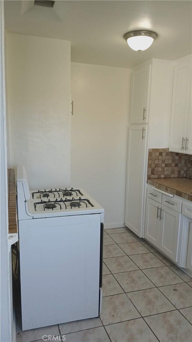 10241 Ruoff Ave, Whittier, CA 90604 - kitchen with white range with gas stovetop, white cabinetry, decorative backsplash, and light tile patterned floors