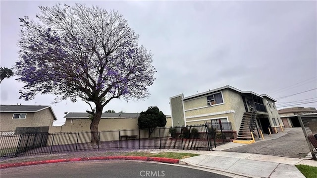 10241 Ruoff Ave, Whittier, CA 90604 - view of front of house featuring stucco siding, stairway, and a fenced front yard