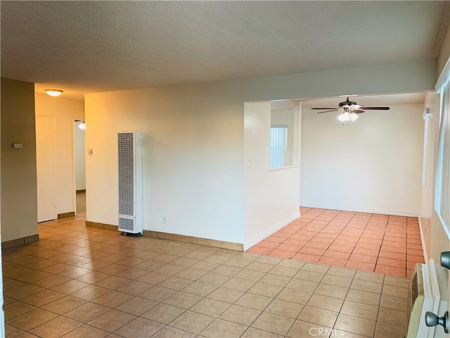 10241 Ruoff Ave, Whittier, CA 90604 - spare room with a heating unit, light tile patterned floors, a ceiling fan, a textured ceiling, and baseboards