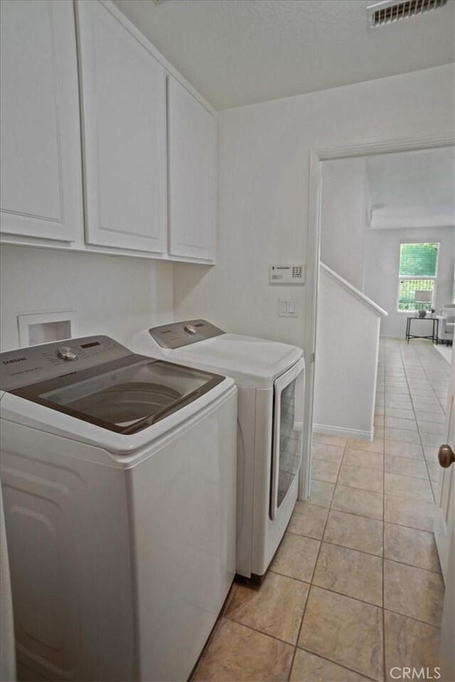 27045 Fairway Ln, Valencia, CA 91381 - laundry room with washer and dryer, cabinet space, and light tile patterned floors