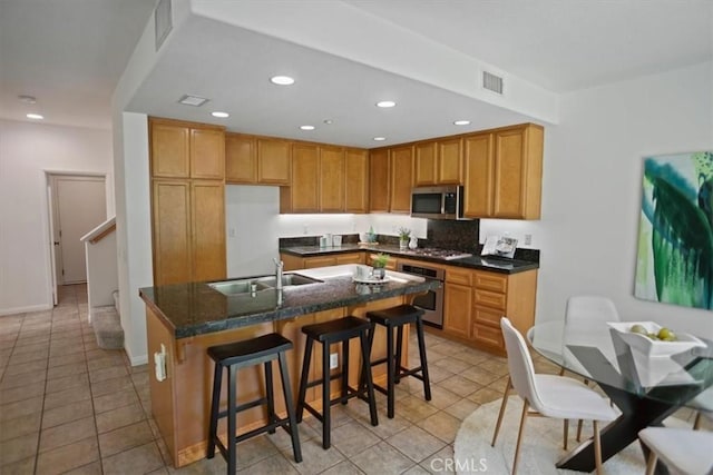 27045 Fairway Ln, Valencia, CA 91381 - kitchen with stainless steel appliances, light tile patterned flooring, recessed lighting, a kitchen island with sink, and a kitchen bar