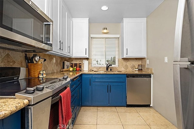 1040 Central Ave Unit 10, Riverside, CA 92507 - kitchen featuring stainless steel appliances, blue cabinets, white cabinetry, a sink, and decorative backsplash